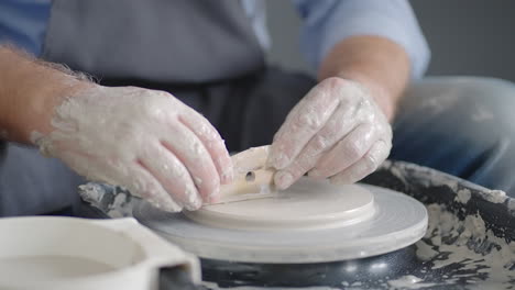 Close-up-of-the-hand-of-a-master-working-on-a-potter's-wheel-for-the-manufacture-of-clay-and-ceramic-jugs-and-plates-in-slow-motion
